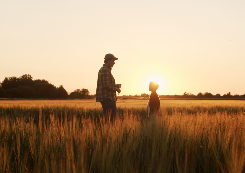 two people standing in field