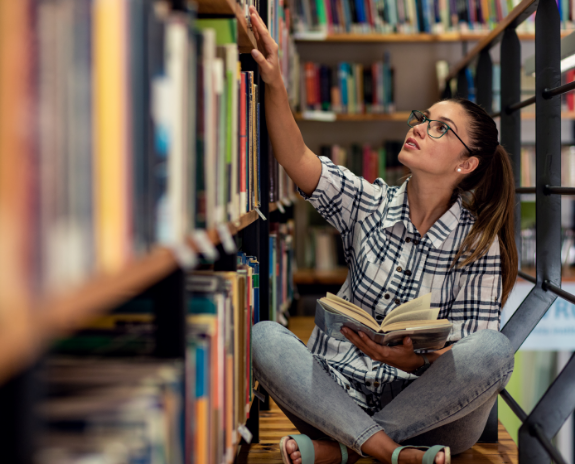 woman looking at books in a library